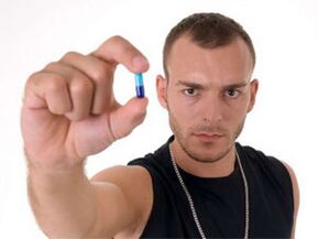 man holding a pill to increase the potency